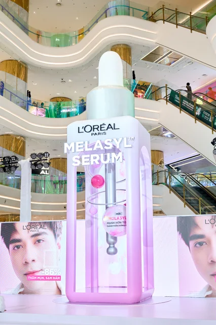A giant illuminated L’Oréal Glycolic Bright Melasyl serum bottle at the centre of the pop-up