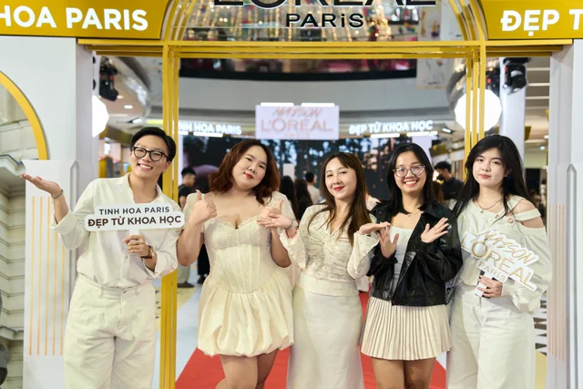 Guests sharing a joyful group moment at the entrance to Maison L’Oréal Paris
