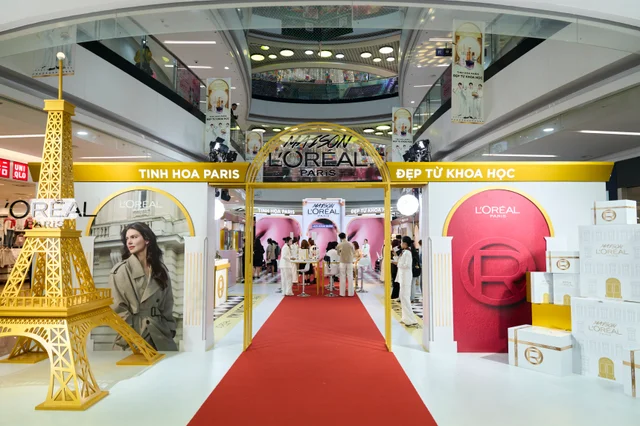 The gold Eiffel Tower, Parisian entrance arch, and red carpet at Maison L’Oréal Paris