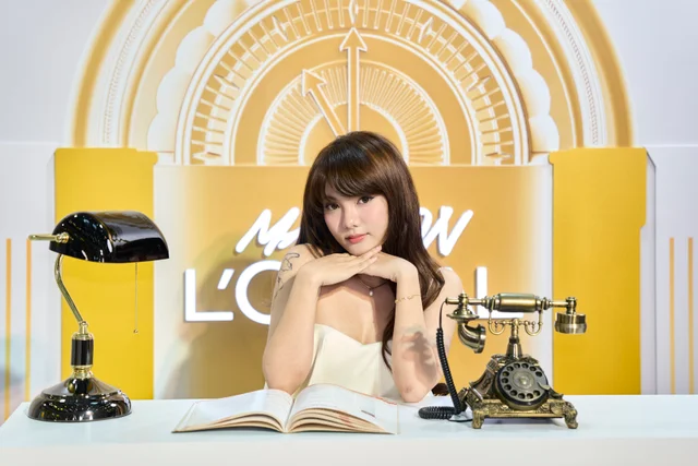 A guest seated at the Maison’s gold clock display with a vintage telephone and open book