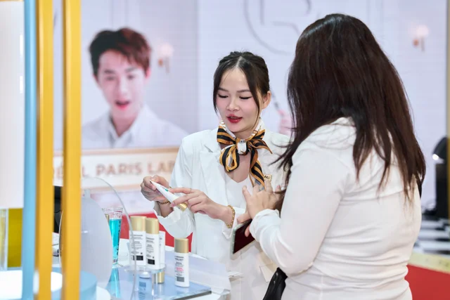 A L’Oréal Paris advisor introducing beauty products to guests at a discovery station