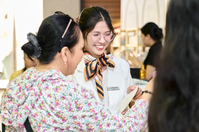 A smiling beauty advisor and guest sharing a product discovery moment